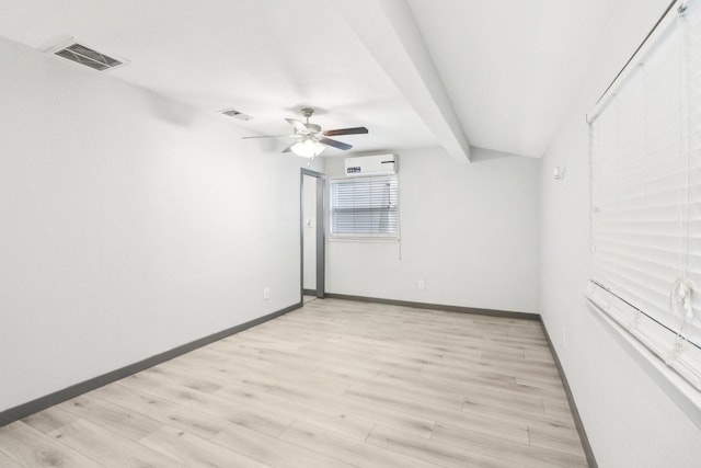 empty room with an AC wall unit, ceiling fan, and light hardwood / wood-style flooring