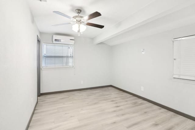 unfurnished room with ceiling fan, beam ceiling, a wall mounted AC, and light wood-type flooring