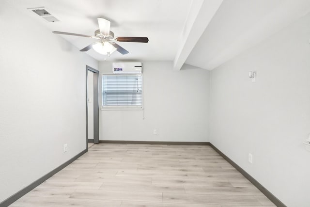 empty room with ceiling fan, light hardwood / wood-style flooring, a wall unit AC, and beamed ceiling