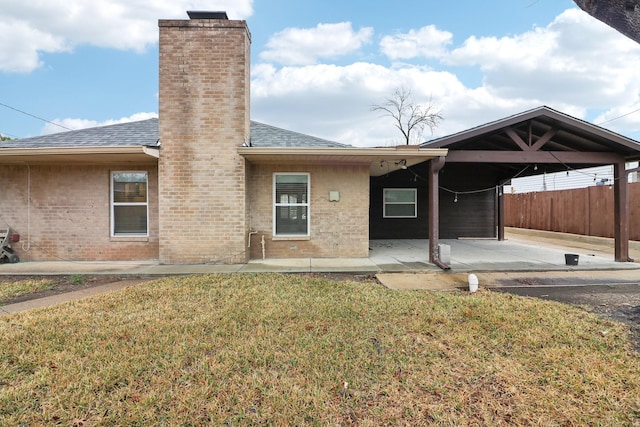 rear view of property with a lawn and a patio area