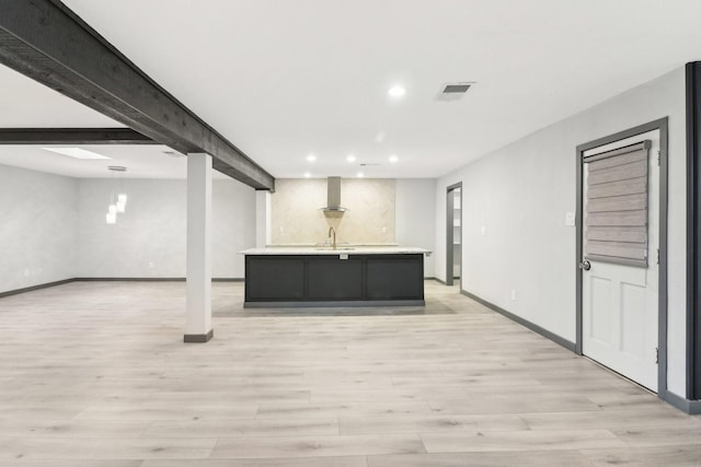 basement with sink and light hardwood / wood-style flooring