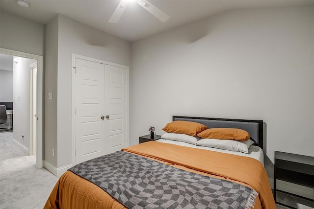 carpeted bedroom with ceiling fan, lofted ceiling, and a closet