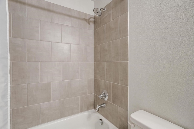 bathroom featuring shower / tub combo and toilet