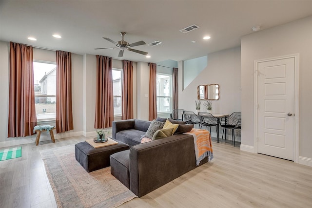 living room with a wealth of natural light, ceiling fan, and light wood-type flooring