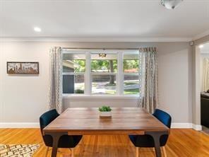 dining area with breakfast area, ornamental molding, and hardwood / wood-style floors