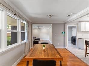 dining space with ornamental molding and light hardwood / wood-style floors