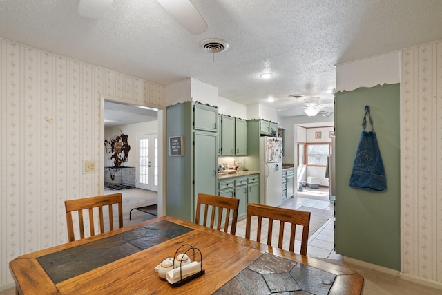 dining room featuring a healthy amount of sunlight, ceiling fan, and a textured ceiling