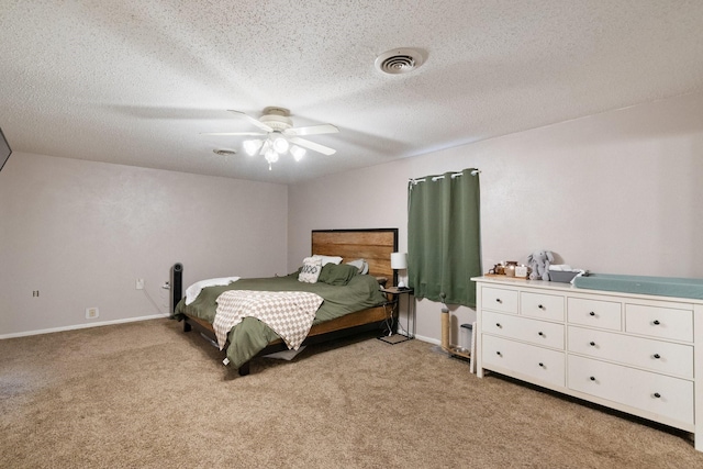 carpeted bedroom featuring ceiling fan and a textured ceiling