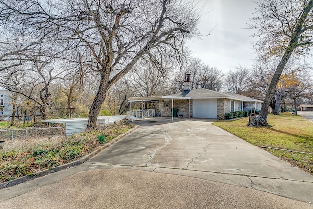 view of front of property featuring a garage, a carport, and a front lawn