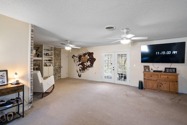 sitting room with ceiling fan, light carpet, french doors, and a textured ceiling