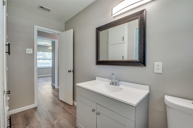 bathroom featuring vanity, hardwood / wood-style floors, and toilet