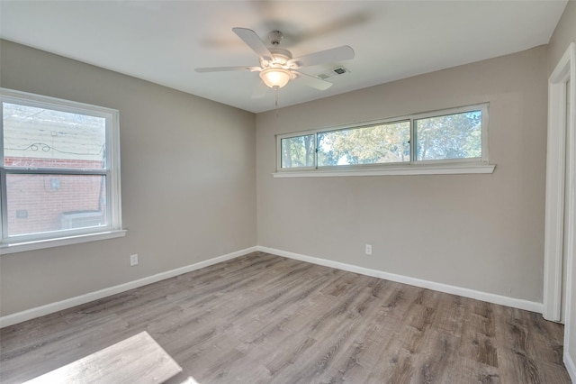 empty room with ceiling fan and light hardwood / wood-style flooring