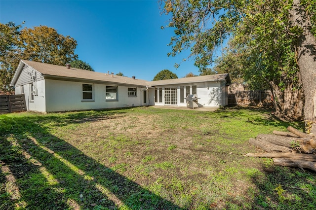 back of property with a yard and a patio area