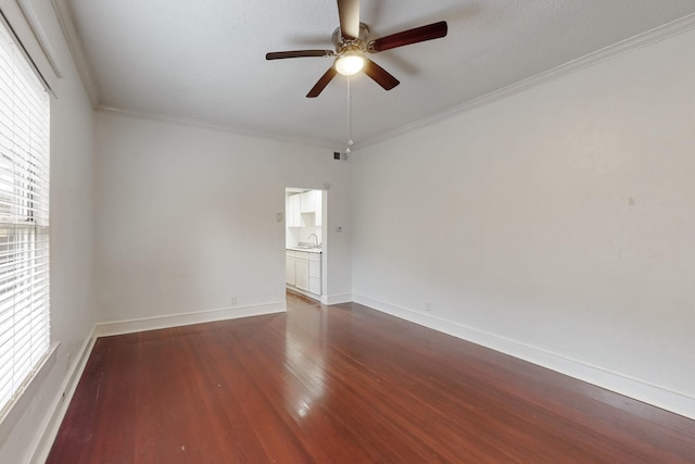 spare room with crown molding, dark hardwood / wood-style floors, sink, and ceiling fan