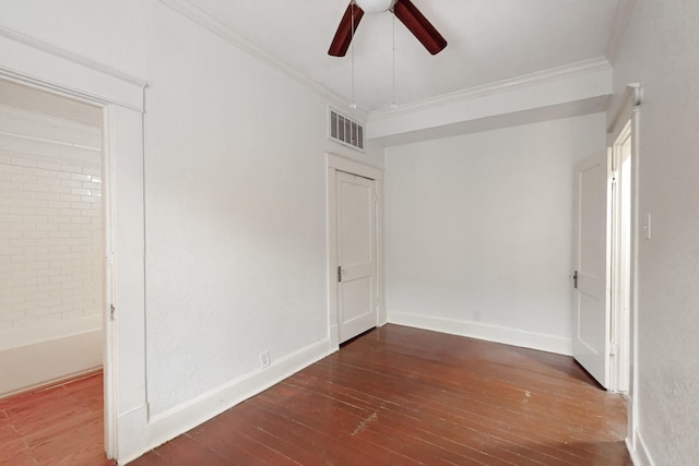 empty room featuring ornamental molding, dark hardwood / wood-style floors, and ceiling fan