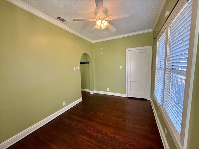 spare room featuring crown molding, a wealth of natural light, and dark wood-type flooring