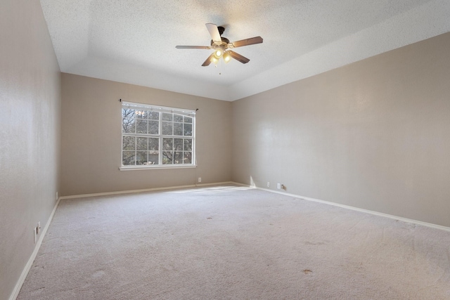 empty room featuring ceiling fan, light carpet, and a textured ceiling