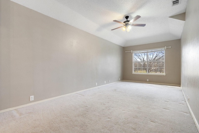 carpeted empty room with lofted ceiling, a textured ceiling, and ceiling fan