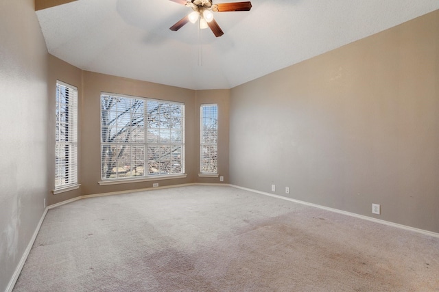 carpeted spare room featuring lofted ceiling and ceiling fan