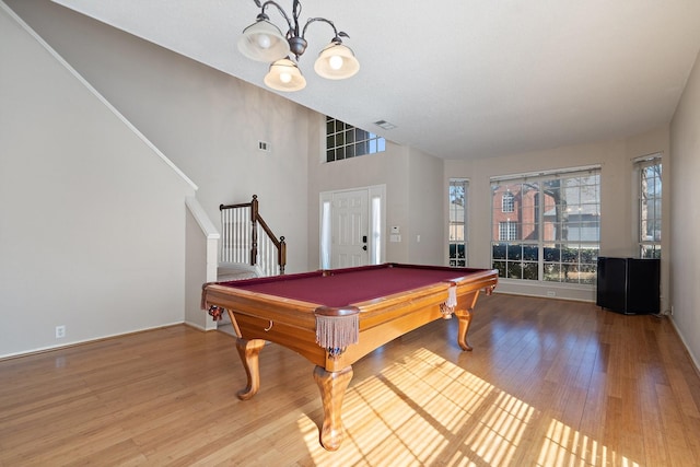 recreation room featuring hardwood / wood-style floors, pool table, and a high ceiling