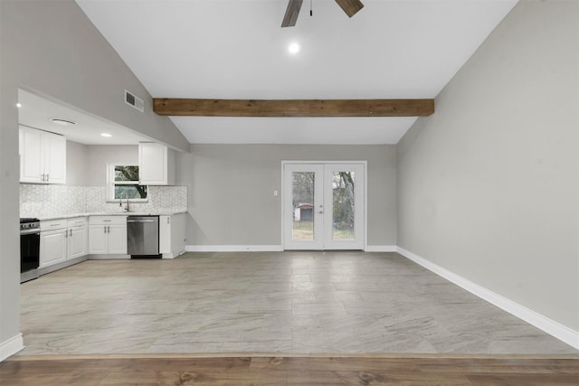 kitchen featuring ceiling fan, appliances with stainless steel finishes, white cabinetry, lofted ceiling with beams, and decorative backsplash