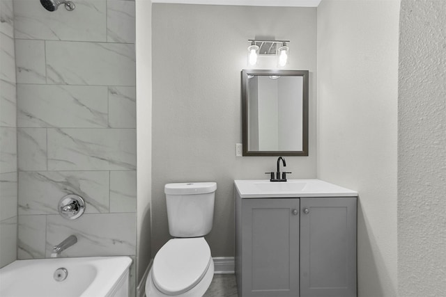 full bathroom featuring tiled shower / bath, vanity, and toilet