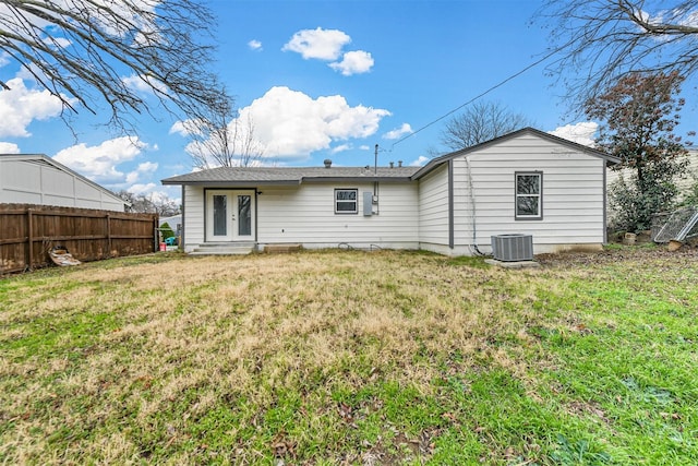 back of property with cooling unit, a yard, and french doors