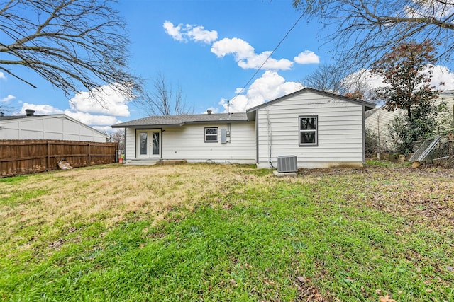 rear view of property featuring central AC unit, a lawn, and french doors