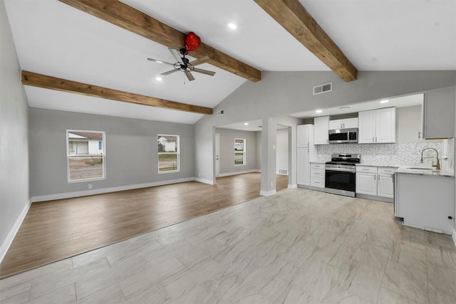kitchen with sink, vaulted ceiling with beams, stainless steel appliances, white cabinets, and decorative backsplash