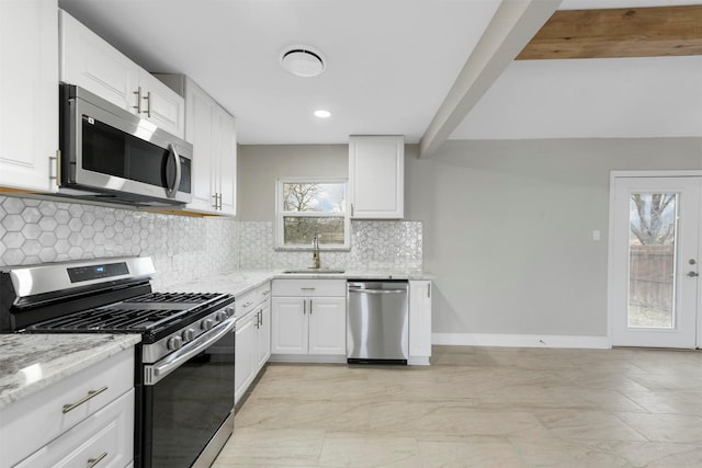 kitchen featuring sink, white cabinetry, stainless steel appliances, tasteful backsplash, and light stone countertops