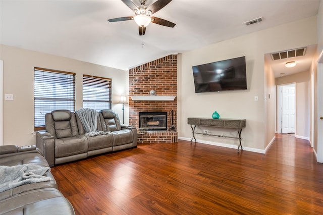 living room featuring vaulted ceiling, a brick fireplace, ceiling fan, and dark hardwood / wood-style flooring