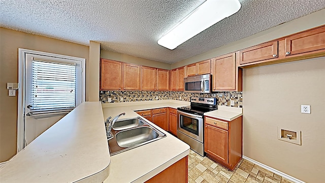 kitchen with sink, decorative backsplash, a textured ceiling, and appliances with stainless steel finishes