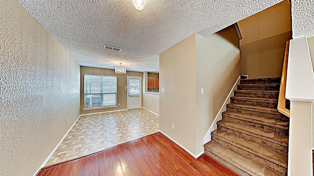 entryway featuring hardwood / wood-style flooring and a textured ceiling