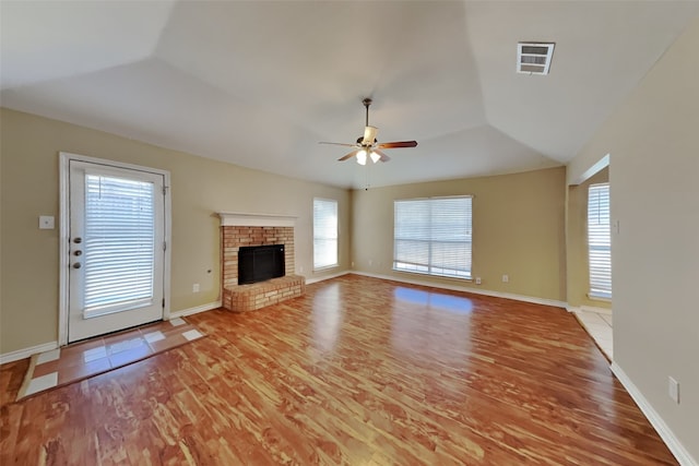 unfurnished living room featuring a healthy amount of sunlight, a fireplace, and light wood-type flooring