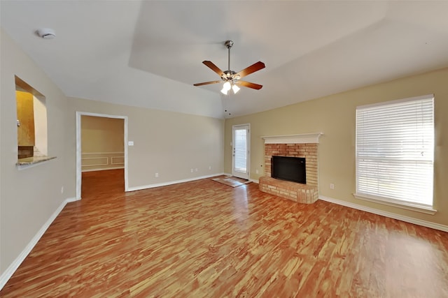 unfurnished living room featuring ceiling fan, lofted ceiling, a fireplace, and light hardwood / wood-style flooring