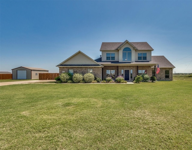 view of front of property with a garage, an outbuilding, and a front lawn