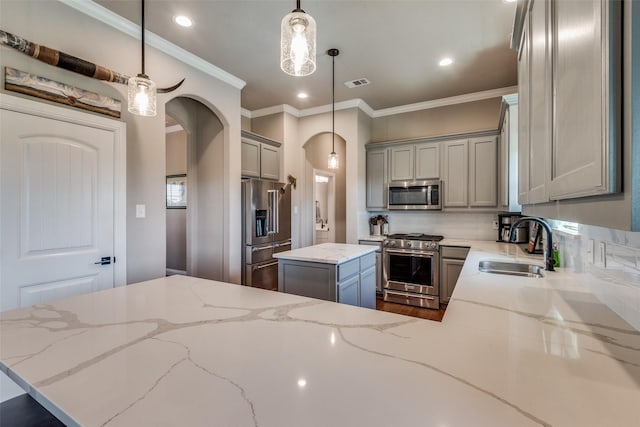 kitchen featuring pendant lighting, sink, gray cabinetry, premium appliances, and kitchen peninsula