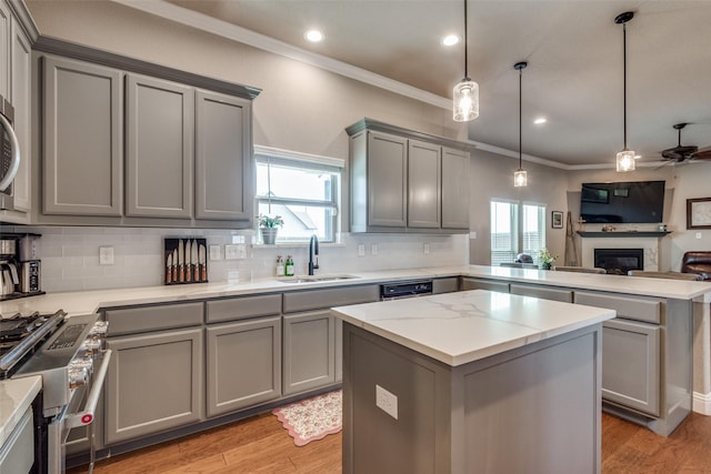 kitchen featuring gray cabinets, pendant lighting, sink, a center island, and high end stainless steel range