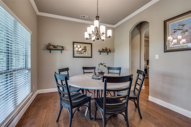 dining room with ornamental molding, a notable chandelier, and dark hardwood / wood-style flooring