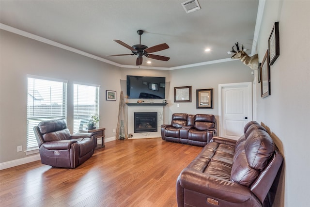 living room featuring ornamental molding, ceiling fan, and light hardwood / wood-style floors