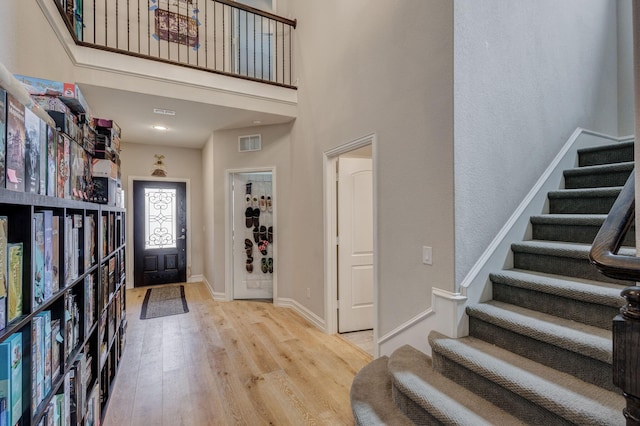 foyer entrance featuring a high ceiling and light wood-type flooring