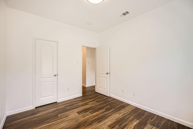 unfurnished bedroom with dark hardwood / wood-style flooring