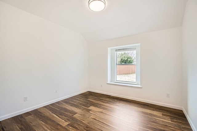 empty room featuring lofted ceiling and dark hardwood / wood-style floors