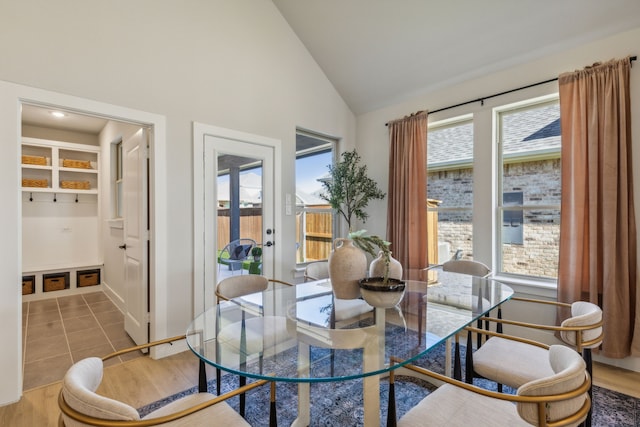 dining area featuring high vaulted ceiling and tile patterned floors