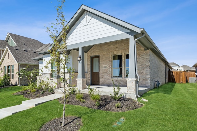 view of front facade featuring covered porch and a front yard