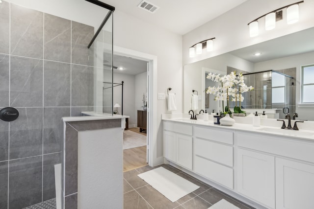 bathroom with walk in shower, tile patterned floors, and vanity