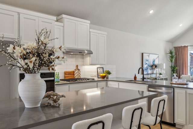 kitchen with sink, a breakfast bar area, stainless steel appliances, and white cabinets