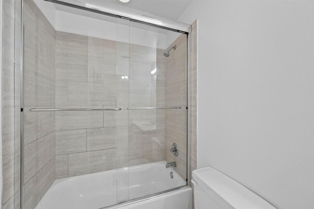 bathroom featuring enclosed tub / shower combo and toilet