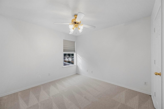 spare room with light colored carpet and ceiling fan