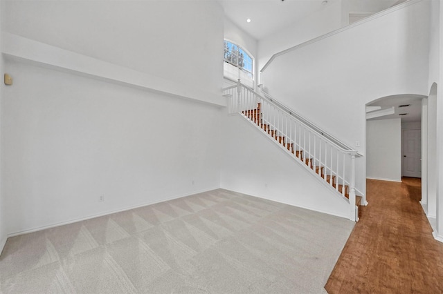 unfurnished living room featuring a high ceiling and carpet